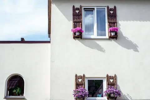 Two windows with flower pots on the facade of the building Fotos de archivo