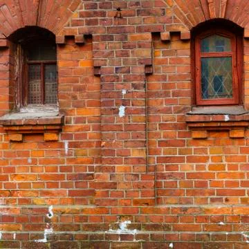 Two windows in the old red brick wall. Design concept. Space for text. Stock Photos