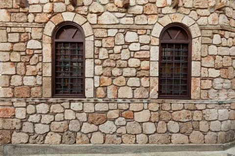 Two windows on old stone wall Stock Photos