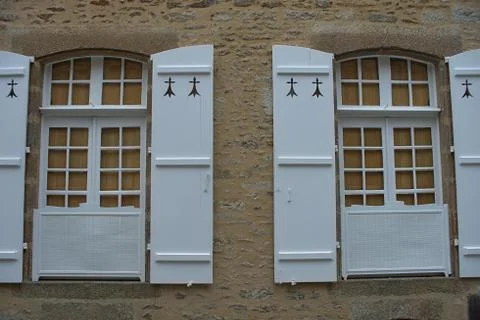 Two windows with old style blinds on stone wall Stock Photos