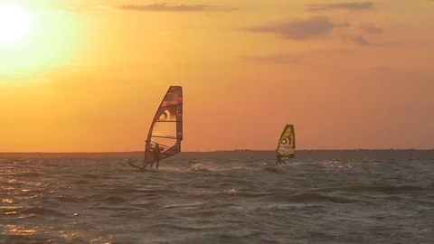 Two windsurfers on the sea at sunset Stock Footage 83707234