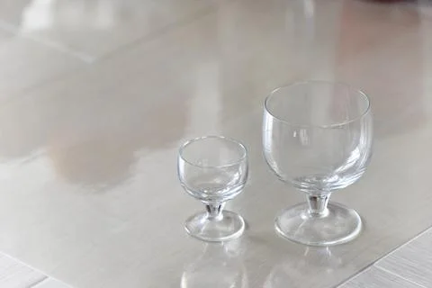 Two wine glasses of different size ob the table Stock Photos