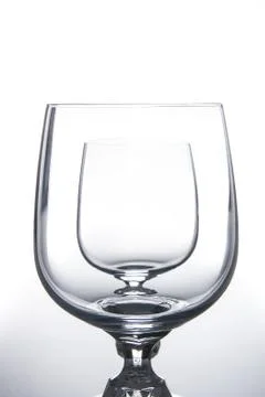 Two wine glasses isolated on light background. Stock Photos