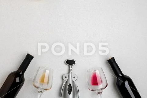 Two wine glasses with red and white wine, bottles of red wine and white wine Stock Photos