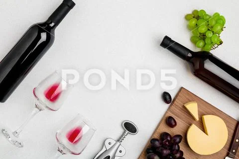 Two wine glasses with red wine,bottle of red wine and cheese on white background Stock Photos