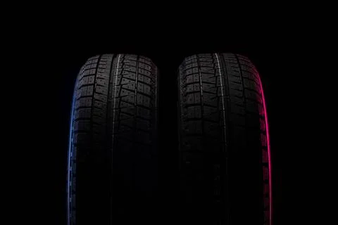 Two winter tires on a black background with red-blue backlighting. two win... Stock Photos