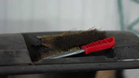 Two wire brushes with red handles resting on dusty shelf. Stock Footage 343891594