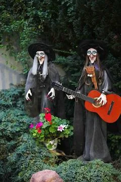 Two witch dolls in black clothes and  hats playing musical instruments Stock Photos