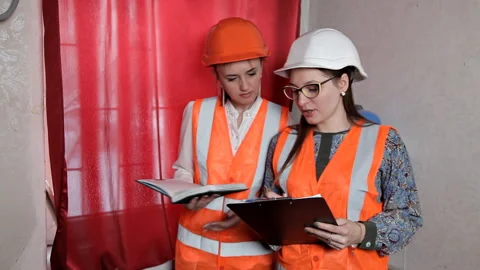 Two woman engineers checking technical data of heating system equipment in a Stock-Footage 103490502