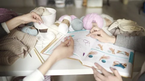 Two woman friends using book with knitting pattern. Knitting needles Stock Footage 87063005