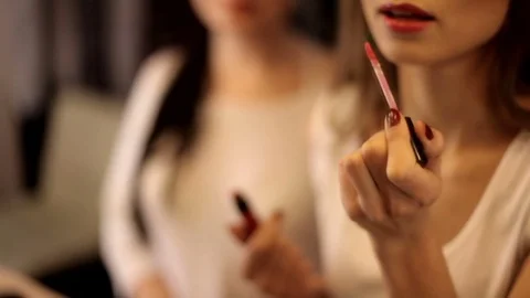 Two Woman in front of a mirror applying makeup onto her face. makeup, preparing Stock Footage 81614097