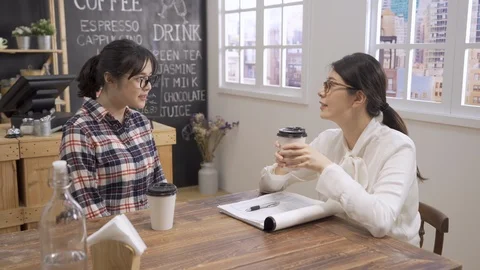 Two woman talking sitting drinking cups of coffee Video stock 112116680