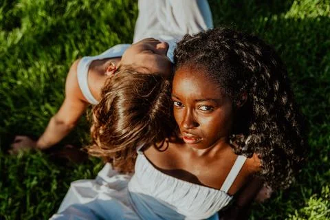 Two women are laying on the grass, one is looking at the camera, integratio.. Stock Photos
