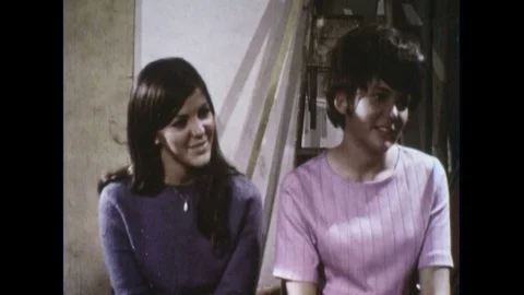 Two women are talking as the woman gives the man the blunt who starts inhaling Stock Footage