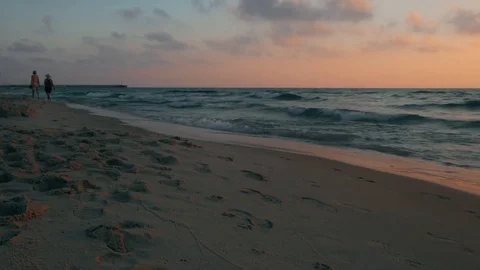 Two women are walking along the seashore at sunset, Mediterranean Sea, Israel. Stock Footage