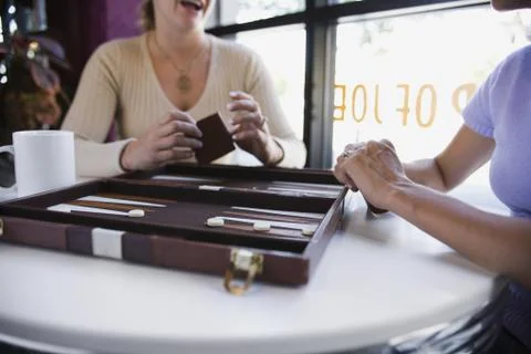 Two women with backgammon game Stock Photos