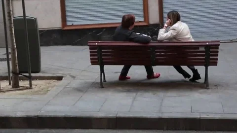Two women chatting on bench Stock Footage 69110568