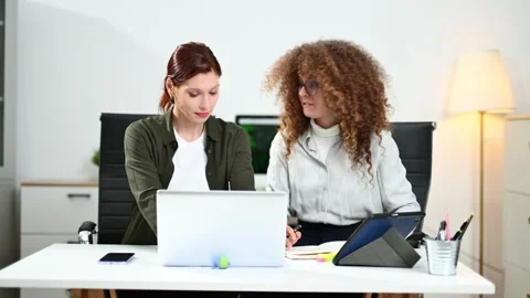 Two women coding together in a high-tech office, showcasing teamwork, softw.. Stock Footage 312603027
