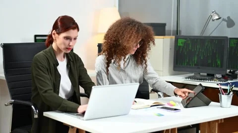 Two women coding together in a high-tech office, showcasing teamwork, softw.. Stock Footage 312603047