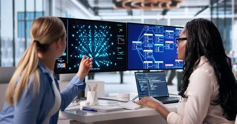 Two Women Collaborate On Artificial Intelligence Models Using Laptops Togethe Stock Photos