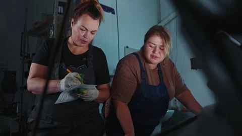 Two women collaborating on a project in a workshop environment Stock Footage 305847428