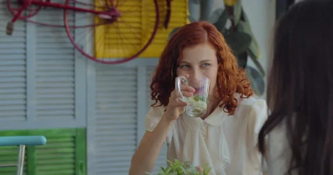 Two women colleagues drinking tea, talking and laughing while having a lunch  Stock Footage 146201509