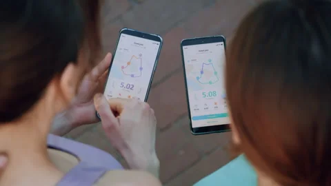 Two women comparing running app results on smartphones 動画素材 336961851