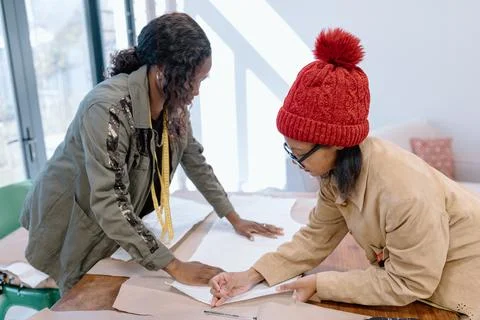 Two women cutting a pattern to sew Stock Photos