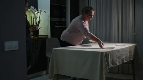 Two women of different generations setting a dining table together 스톡 동영상 340061948