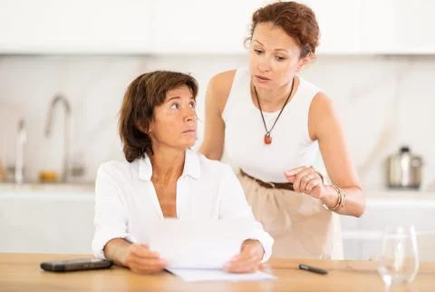 Two women discuss documents, try to solve financial problems 스톡 사진