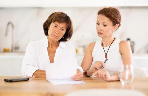 Two women discuss documents, try to solve financial problems Fotos Stock