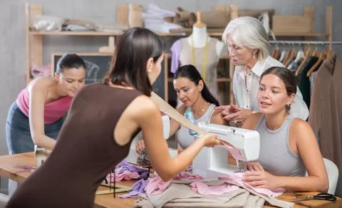 Two women discussing pattern at sewing master class Stock Photos