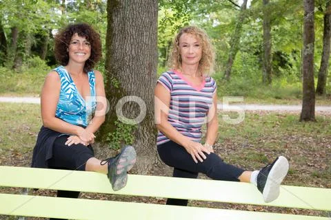 Two women is doing warming up before running on a beautiful summer day Stock Photos