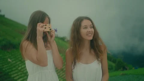 Two Women Dressed in Elegant White Dresses Enjoying a Scenic Vineyard Adventure Stock Footage 280969899