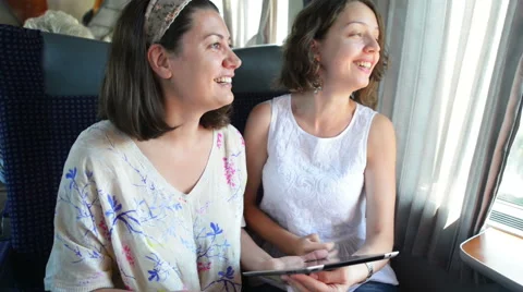 Two women enjoying travel by train Stock Footage