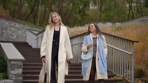 Two Women Gracefully Walking Down the Stairs in Cozy Autumn Fashion and Stylish  Stock Footage 297391366
