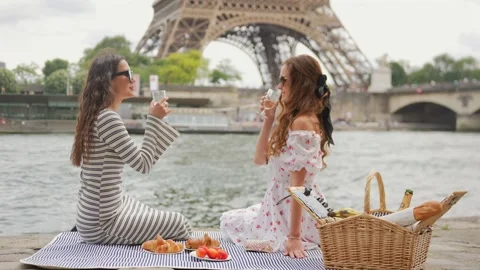 Two women having picnic by Eiffel Tower in Paris on summer day Stock Footage 313598620
