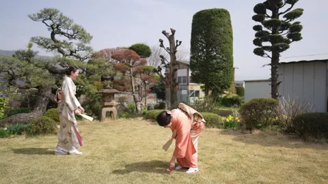 Two women in kimonos stroll through a traditional garden Stock-Footage 341533372