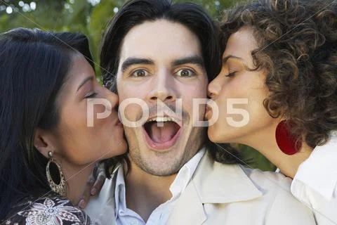 Two Women Kissing Man On Cheek