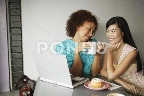 Two Women With Laptop And Coffee And Donuts
