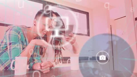Two women leaning and tapping phone at kitchen counter, activating tech UI Stock Footage 334368755