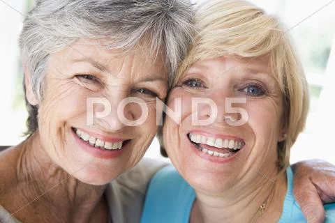 Two women in living room smiling Stock-Fotos