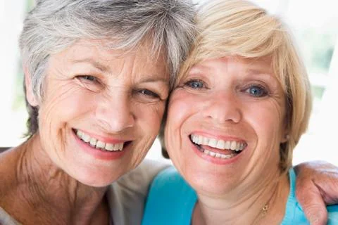 Two women in living room smiling Stock Photos