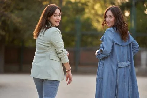 Two women looking to camera while enjoying a walk in a park. Foto stock