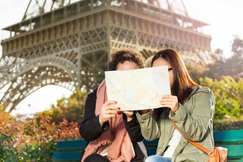 Two women looking at map during excursion in Paris Foto stock