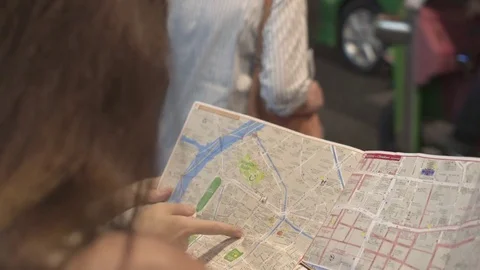 Two women looking at the map on the street Stock Footage