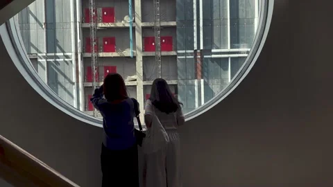 Two women looking through the window at construction site of the new building. Video stock 209169659