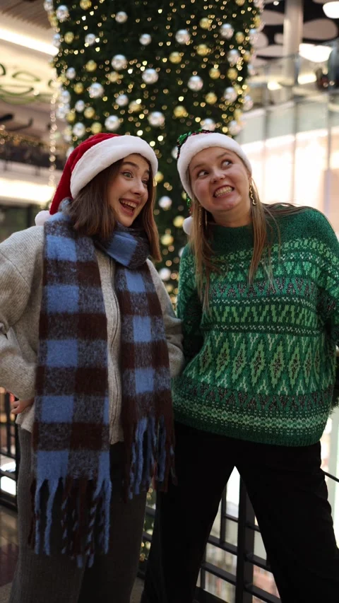Two women making funny faces under christmas tree Stock Footage 324814745