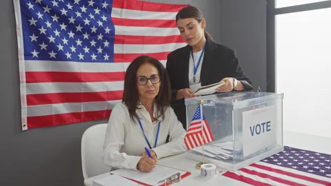 Two women overseeing the voting process in an american electoral room with .. Video stock 276545801