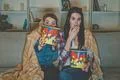 The two women with a popcorn watch a horror movie on the sofa Photo